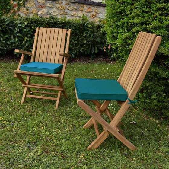 Coussins bleu canard présentés avec les chaises et fauteuils en teck Karimun