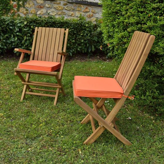 Coussins corail présentés avec les chaises et fauteuils en teck Karimun