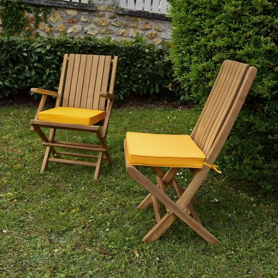 Coussins jaunes présentés avec les chaises et fauteuils pliants en teck Karimun