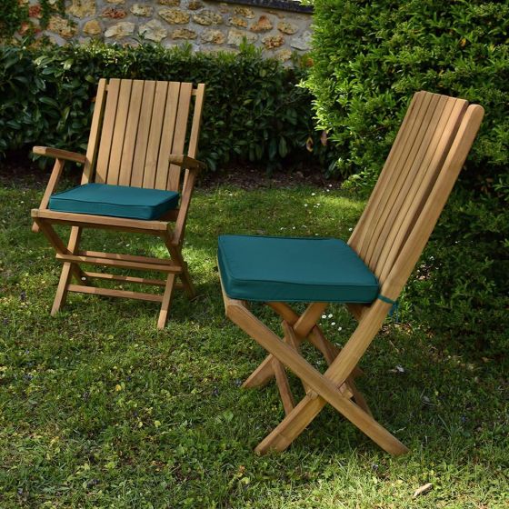 Coussins vert présentés avec les chaises et fauteuils en teck Karimun