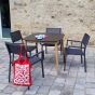 Table de jardin carrée avec pieds en teck et plateau en Duranite® noir 90 x 90 cm Kimito présentée avec les sièges Leda